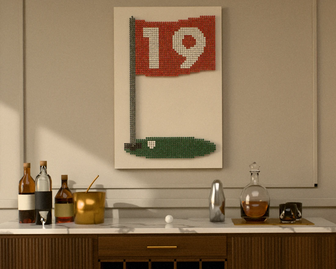 A golf-tee picture of a red pin flag numbered 19 over a green with a cup and a ball, hung tall on a light greige paneled wall above a walnut bar cabinet with a marble top, wine bottles in its cubbies, spirits, a brass ice bucket and a crystal decanter.