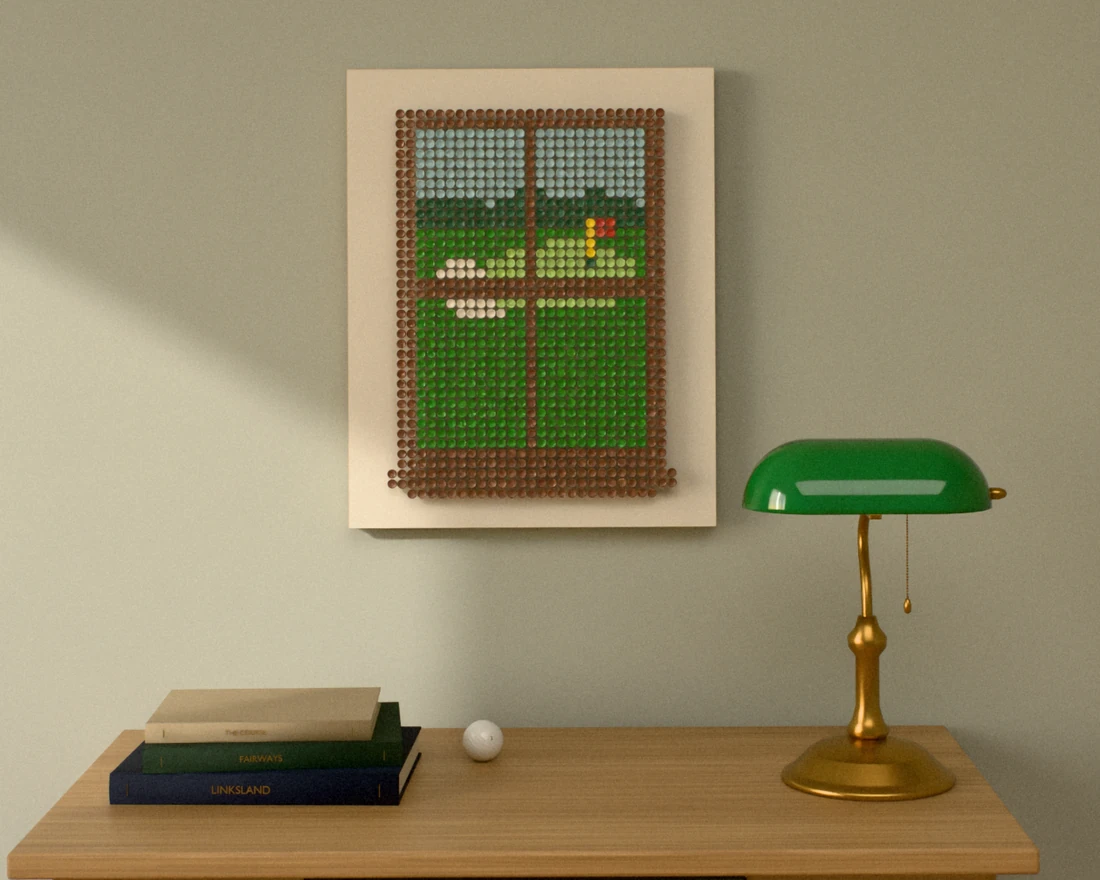 A golf-tee picture of a green seen through a walnut window, hung on a sage wall above a small oak writing desk with a green banker’s lamp and books.
